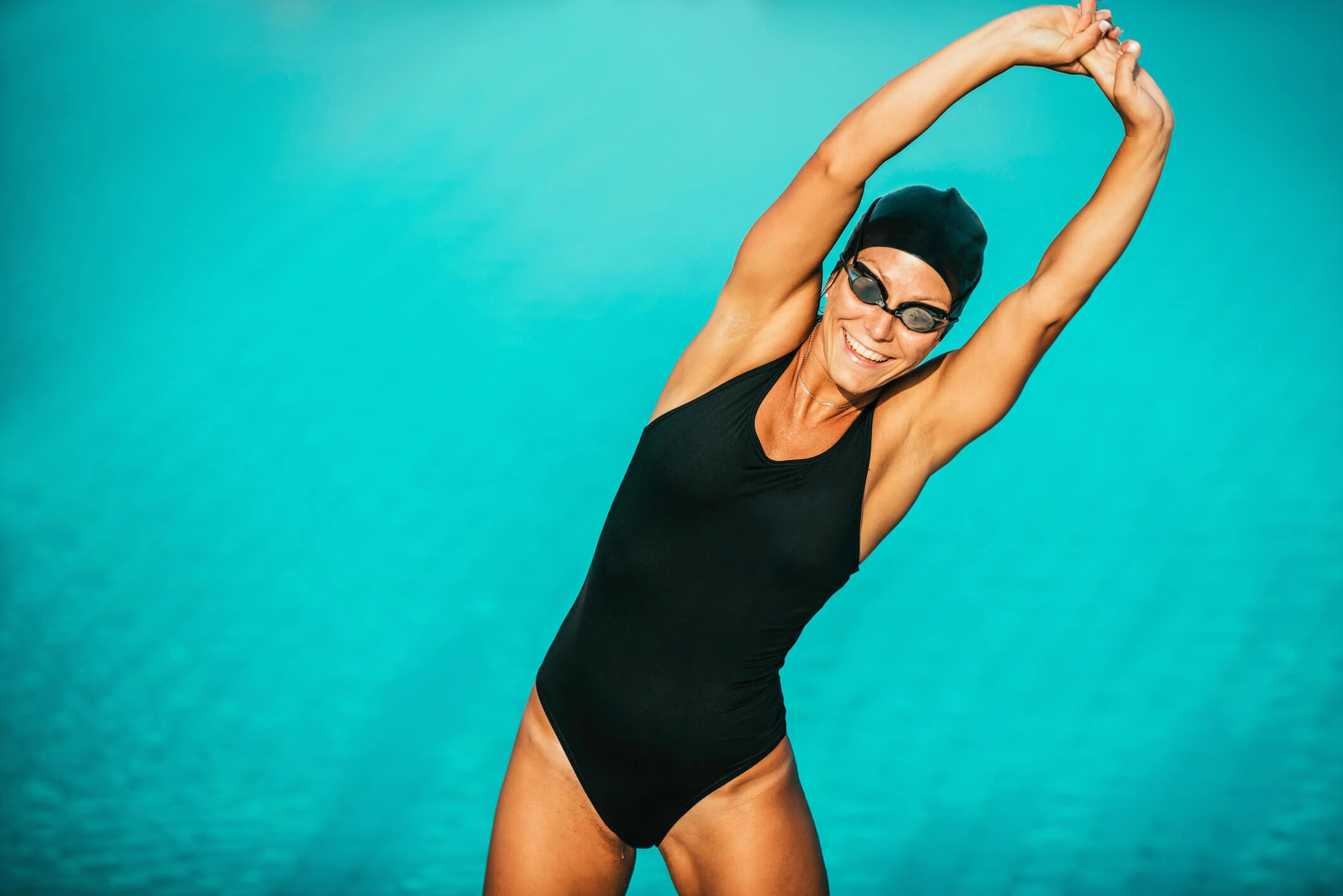 Une femme devant la piscine s'étire